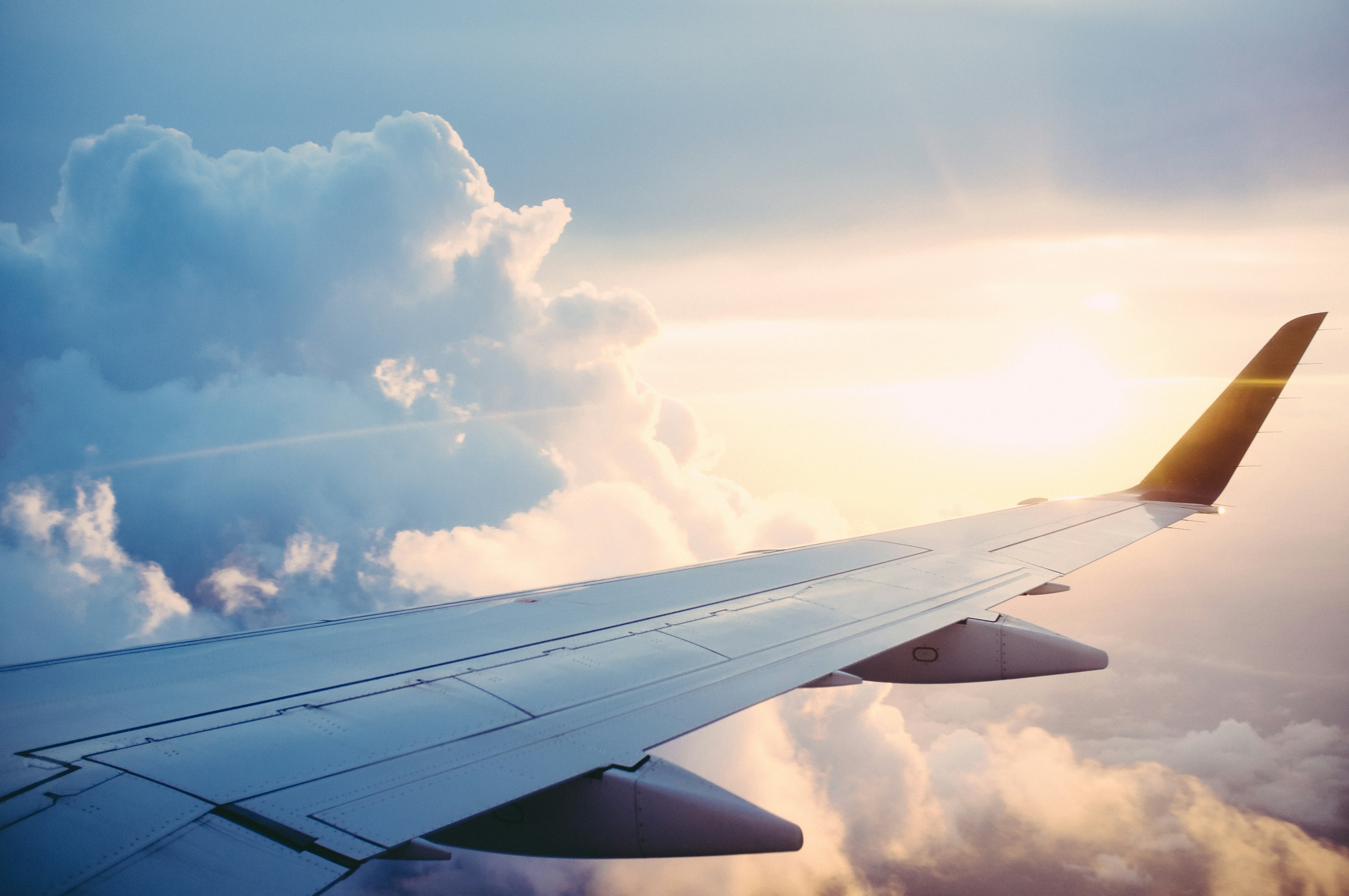 Aircraft wing above the clouds at sunset